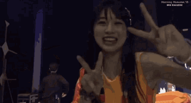 a woman is giving a peace sign with her hands