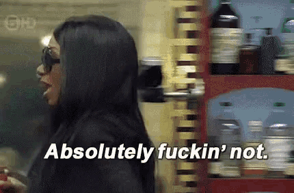 a woman is standing in front of a shelf with bottles and says absolutely fuckin ' not