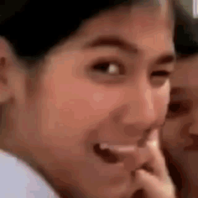 a close up of a woman 's face with her mouth open and a man behind her .