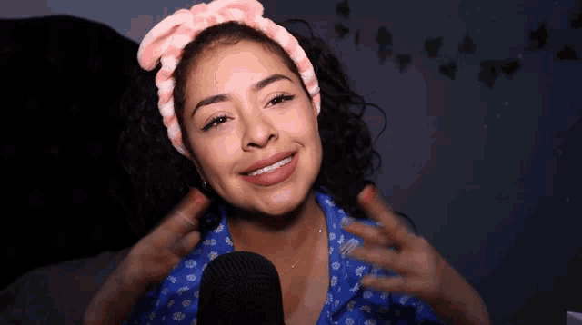 a woman with braces on her teeth smiles in front of a black microphone