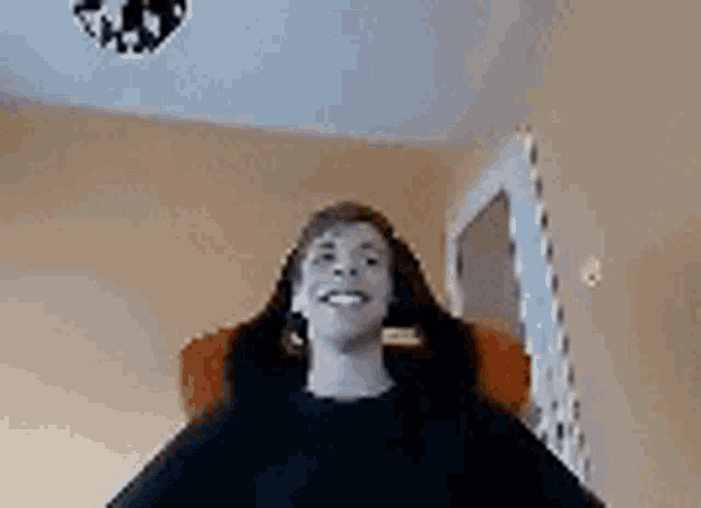 a person is sitting in a chair with their mouth open and their hands on their head .