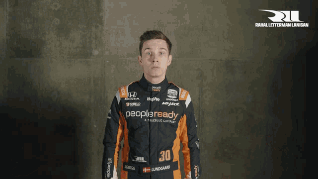 a man in a racing suit with the number 30 on the front