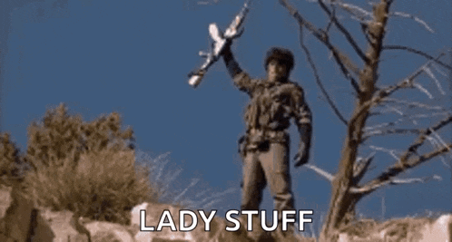a man in a military uniform is holding a rifle and says wolverines !!!