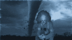 a clown standing in front of a tornado in a field