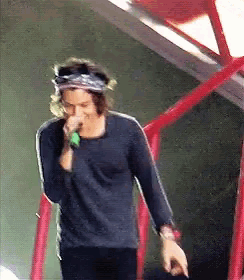 a man is singing into a microphone while wearing a headband