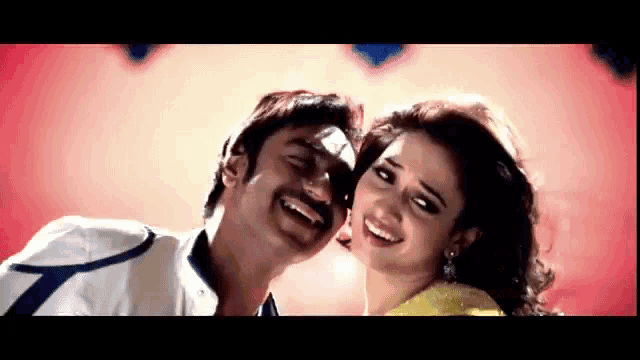 a man and a woman are smiling and looking at the camera .