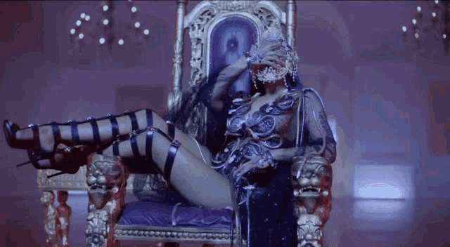 a woman is sitting on a throne in a dark room