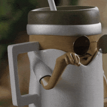a statue of a coffee cup with a straw and sunglasses that says stanley
