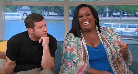 a man and a woman are sitting on a couch in front of a window