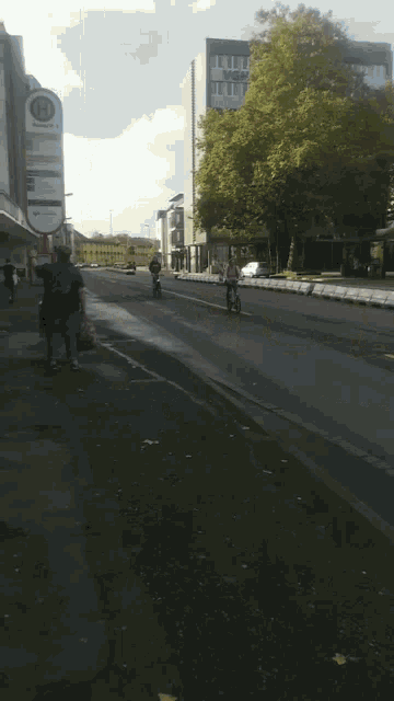 a woman riding a bike down a street next to a motorcycle