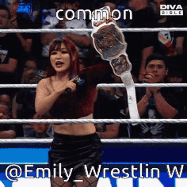 a woman in a wrestling ring holds a championship belt