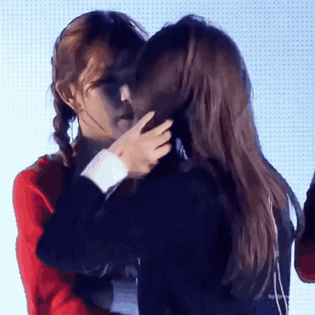 two girls are kissing each other on the cheek .