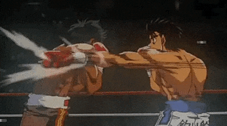 two men are boxing in a ring and one of them is throwing a punch .
