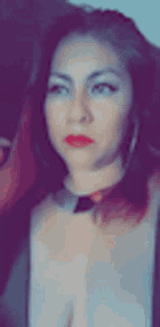 a blurry picture of a woman wearing a choker and red lipstick .