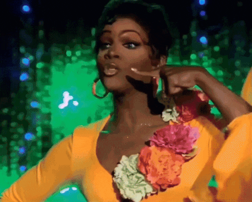 a woman in a yellow top with flowers on it is pointing