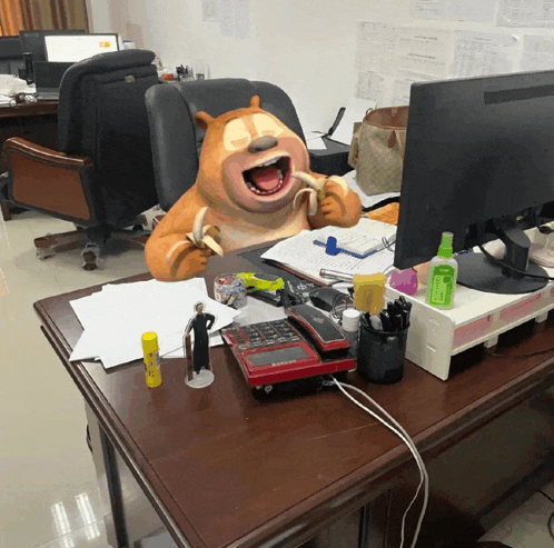a cartoon bear is eating a banana on a desk in front of a computer