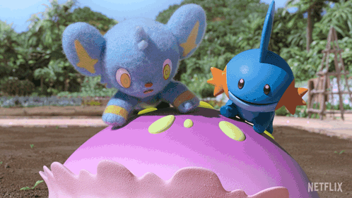 two stuffed animals are sitting on top of a purple object with a netflix logo in the background