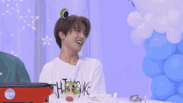 a young man wearing a white shirt that says " tsubasa " on it