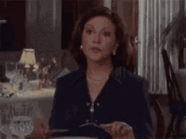 a woman is sitting at a table with a plate of food .