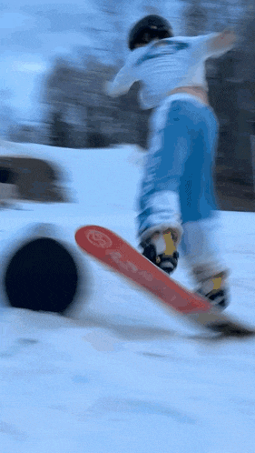 a snowboarder wearing a shirt that says ' a ' on it is going down a snowy hill
