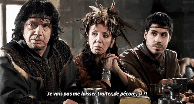 two men and a woman are sitting at a table with the words je vais pas me laisser traiter de pécore si ?