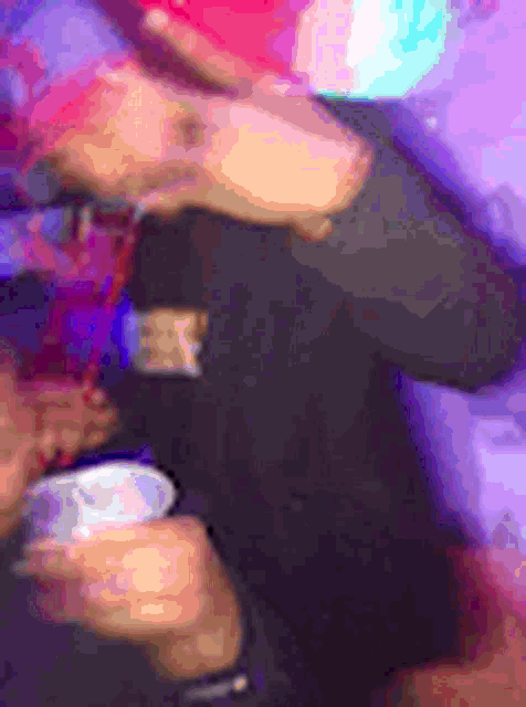 a blurry picture of a person holding a drink in a club .