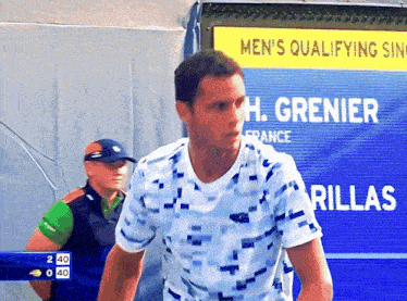 a man stands in front of a sign that says " men 's qualifying "