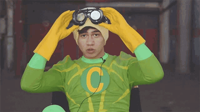 a man in a green and yellow outfit with the letter c on the chest