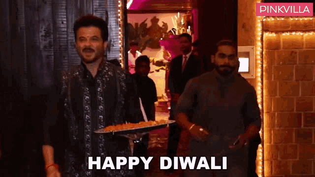 a man carrying a tray of food with the words happy diwali written on the bottom