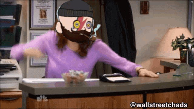 a woman in a purple shirt is sitting at a desk with a cartoon of a man with a beard