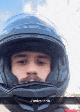 a man wearing a helmet with the words j'arrive tarlik on the bottom right