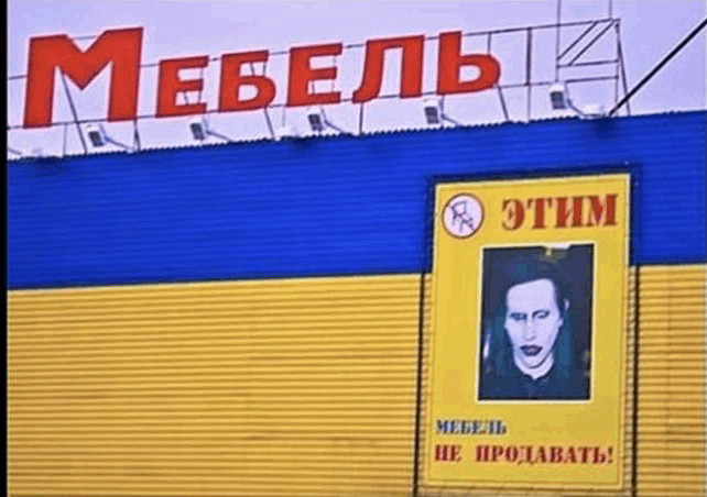 a yellow sign with a picture of marilyn manson is on a blue building