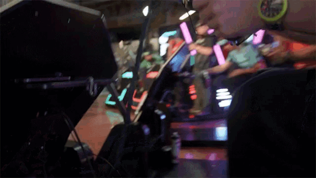 a person wearing a yellow watch is playing a video game in a dark room