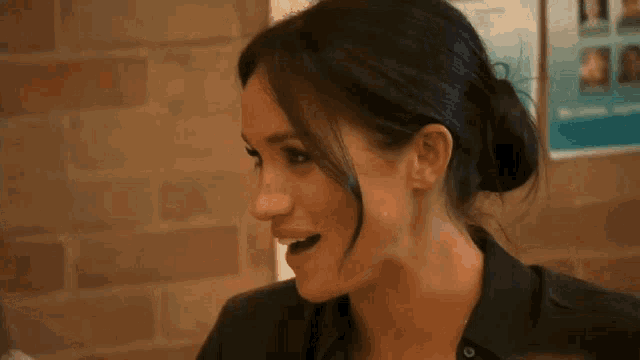 a close up of a woman 's face with her mouth open and a bun .