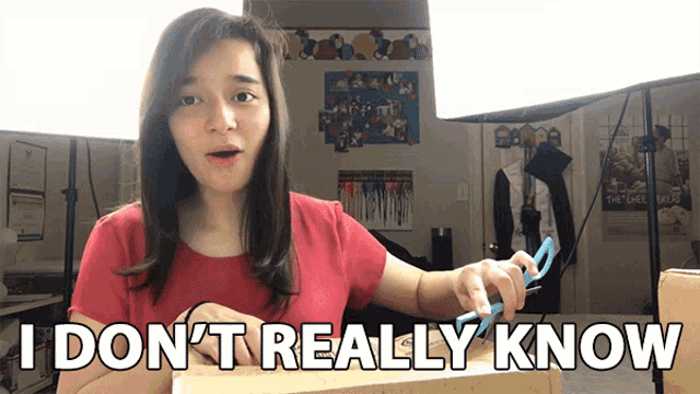 a woman is holding a pair of scissors in front of a sign that says i don 't really know