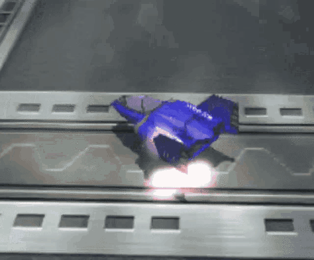 a blue object is flying through the air on a gray surface