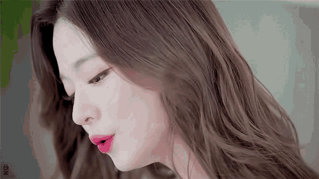 a close up of a woman 's face with red lipstick on her lips