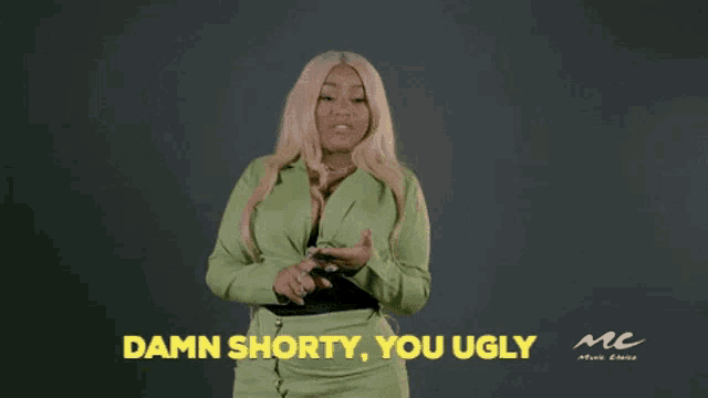 a woman in a green suit is standing in front of a black background and says damn shorty , you ugly .