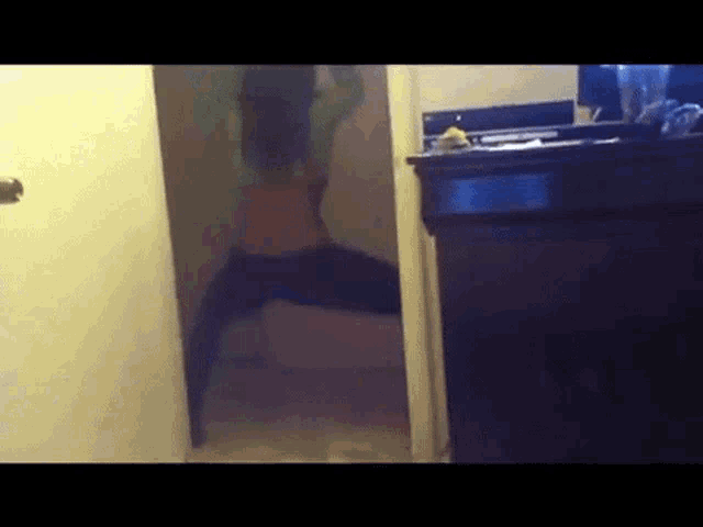 a woman is standing in a hallway in front of a mirror
