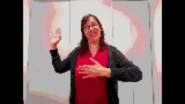 a pixelated image of a woman in a red shirt and black cardigan .
