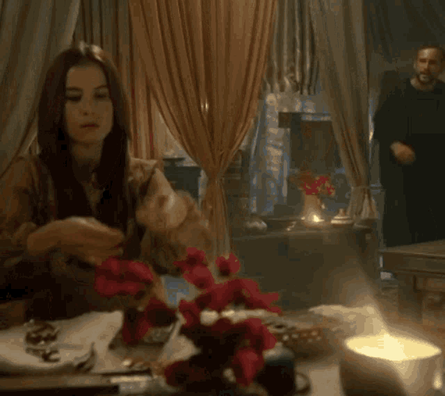 a man and a woman are sitting at a table with a candle in front of them