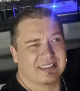 a close up of a man 's face with a blue light behind him