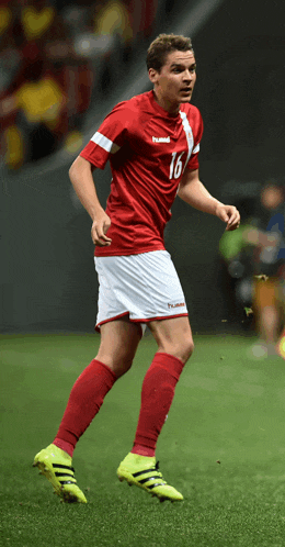 a soccer player wearing a red and white hummel jersey