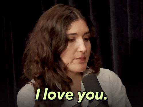 a woman says i love you in front of a black curtain