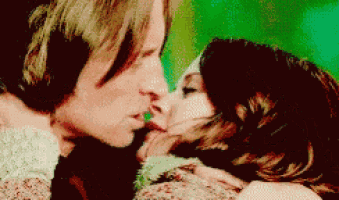 a man and a woman are kissing in a green background