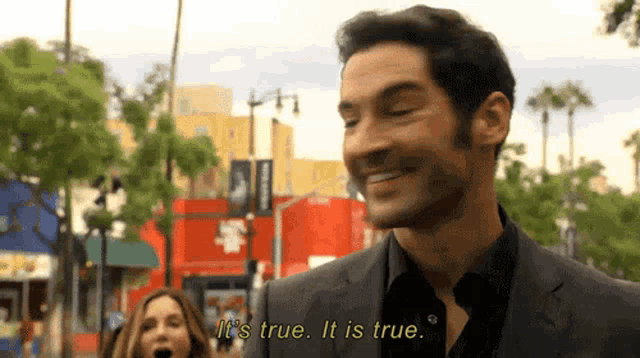 a man in a suit is smiling and saying it 's true .