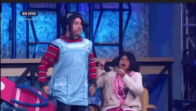 a man and a woman are standing next to each other on a stage in a comedy show .