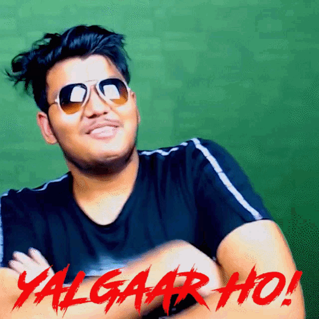 a man wearing sunglasses and a black shirt with the words yalgaar ho written in red