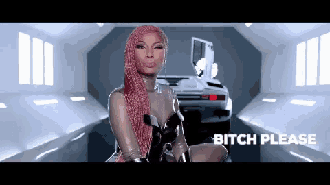 a woman with pink hair is sitting in a room with a car in the background and says bitch please .
