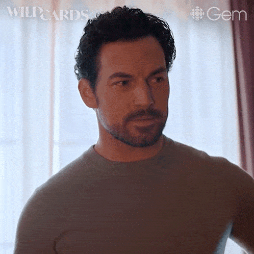 a man with a beard is standing in front of a window with the words wildcards and gem on the bottom